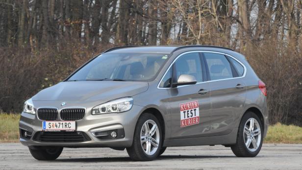 Ein grauer BMW 2er Active Tourer steht auf einem Parkplatz.