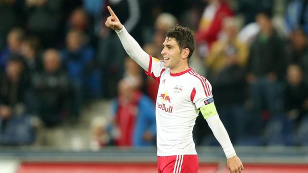 Ein Fußballspieler in weiß-rotem Trikot jubelt mit erhobenem Zeigefinger.