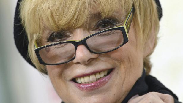 Nahaufnahme des Gesichts einer lächelnden Frau mit Brille.