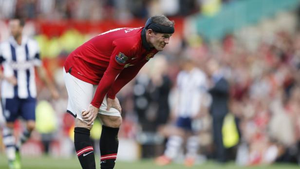 Wayne Rooney, mit Kopfschutz, stützt sich erschöpft auf seine Knie während eines Fußballspiels.