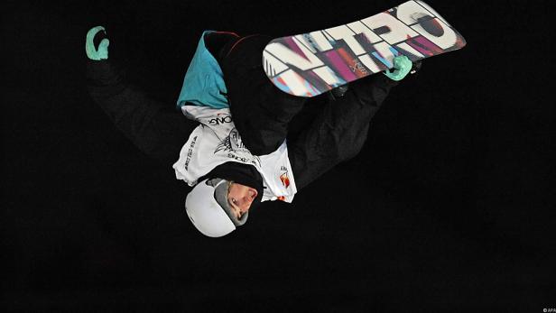 Eine Snowboarderin führt einen Trick in der Luft vor.