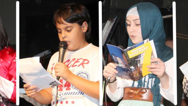 Vier Kinder unterschiedlicher Herkunft lesen bei einer Veranstaltung vor Publikum vor.