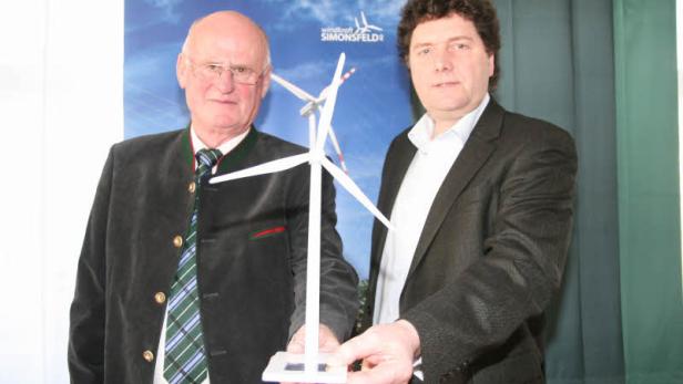 Zwei Männer präsentieren ein Modell eines Windrads von Windkraft Simonsfeld.