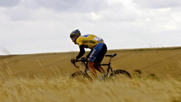 Ein Radfahrer fährt durch ein Feld mit hohem, goldenem Gras.
