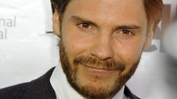 Porträt des Schauspielers Daniel Brühl mit Bart und braunen Augen.