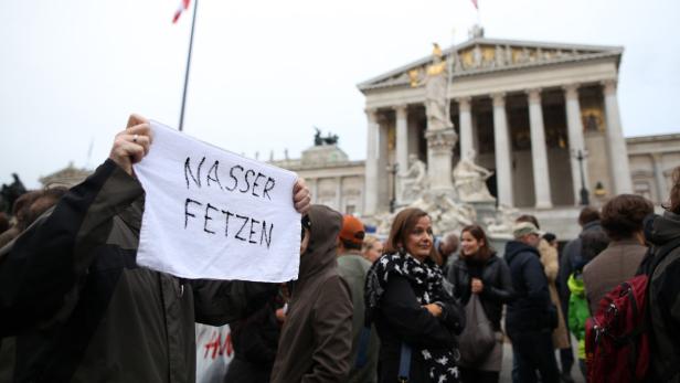 Eine Demonstration vor dem österreichischen Parlament mit einem Schild „Nasser Fetzen“.
