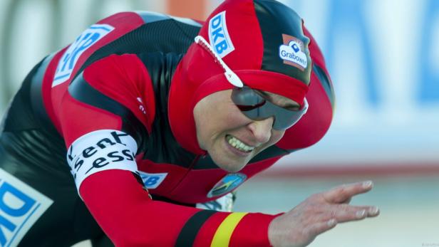 Eine Eisschnellläuferin in rot-schwarzem Anzug während eines Rennens.