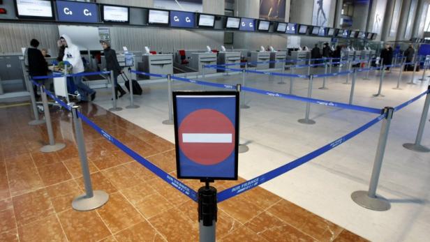 Ein Wartebereich mit Absperrungen vor den Check-in-Schaltern eines Flughafens.