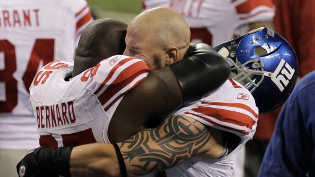 Zwei Footballspieler der New York Giants umarmen sich innig.