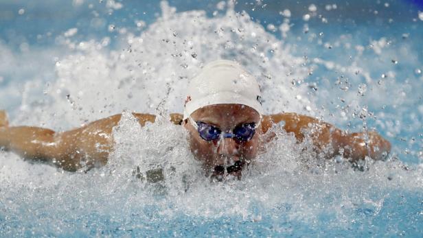 Eine Schwimmerin beim Schmetterlingsstil in einem Schwimmbecken.