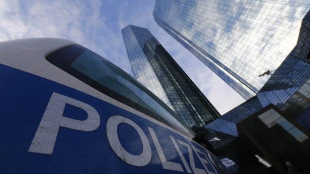 Police vehicles are parked outside the headquarters of Germany&#039;s largest business bank, Deutsche Bank AG in Frankfurt December 12, 2012. Deutsche Bank on Wednesday said its Frankfurt offices were being searched by prosecutors probing a tax evasion scheme involving the trading of carbon permits. The prosecutor said the probe related to severe tax evasion, money laundering and obstruction of justice, with the investigation targeting 25 employees of the bank. Deutsche Bank said it was cooperating fully with the authorities. REUTERS/Kai Pfaffenbach (GERMANY - Tags: BUSINESS CRIME LAW TPX IMAGES OF THE DAY)