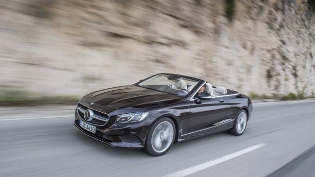 Ein dunkles Mercedes-Benz S-Klasse Cabriolet fährt auf einer Straße.