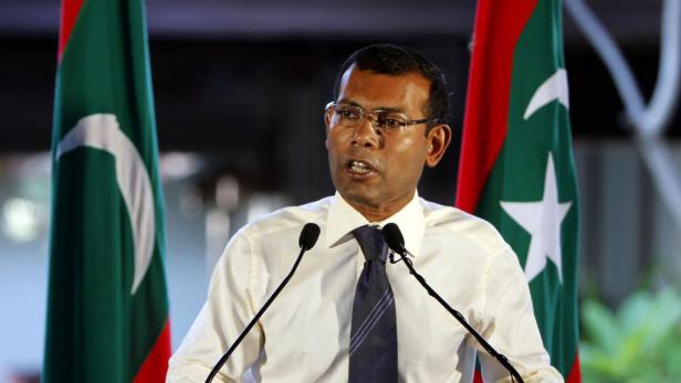 Mohamed Nasheed spricht vor zwei maledivischen Flaggen.