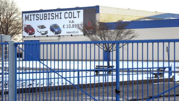 Ein Werbeplakat für den Mitsubishi Colt an einem Gebäude im Winter.