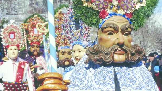 Eine Gruppe von maskierten Personen in traditionellen bayerischen Faschingskostümen.