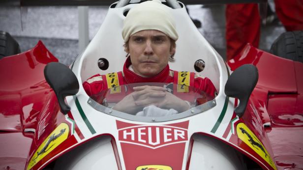 Daniel Brühl als Niki Lauda in einem roten Ferrari-Rennwagen.