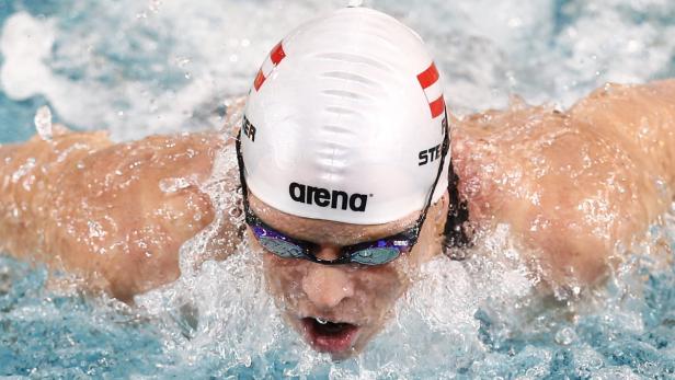 Eine Schwimmerin mit Badekappe und Schwimmbrille schwimmt im Wasser.