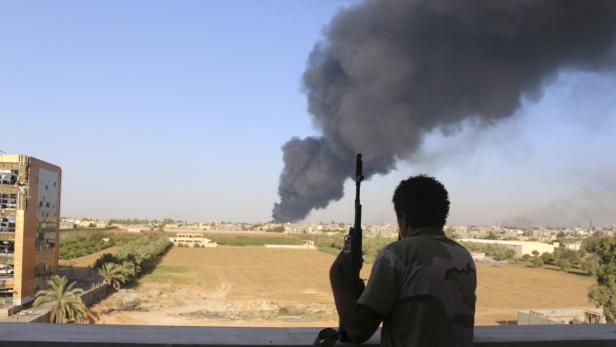 Rauchsäule über Tripolis: Für die Bewohner der libyschen Hauptstadt ein gewohnter Anblick – ebenso wie die zahlreichen verfeindeten Milizen-Kämpfer