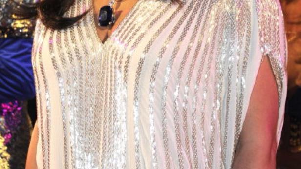 Anna Netrebko trägt ein paillettenbesetztes Kleid und Schmuck.