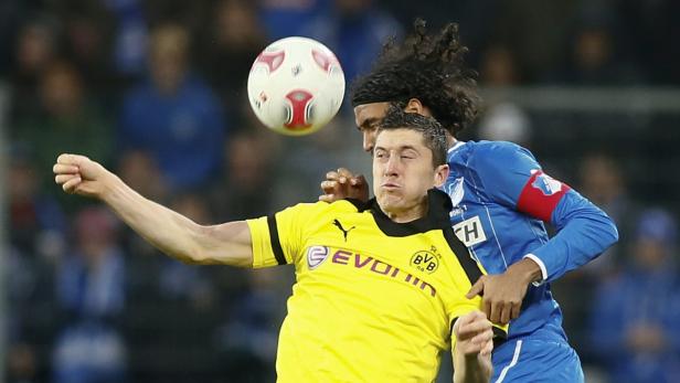 Zwei Fußballspieler kämpfen um den Ball während eines Spiels.