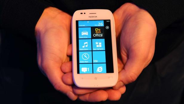 Ein weißes Nokia Smartphone mit Windows Phone wird in zwei Händen gehalten.