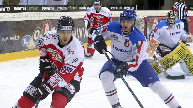 Eishockeyspieler in rot-weißen und blau-weißen Trikots auf dem Eis.