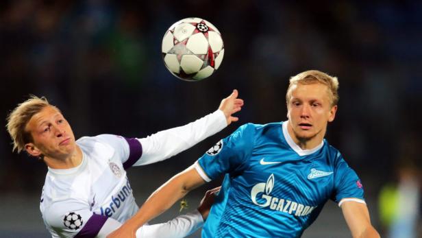 Zwei Fußballspieler kämpfen um einen Ball während eines Spiels.