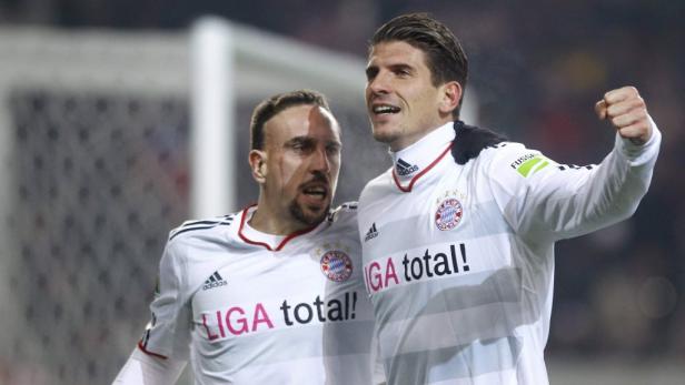 Franck Ribéry und Mario Gómez feiern zusammen auf dem Fußballfeld.