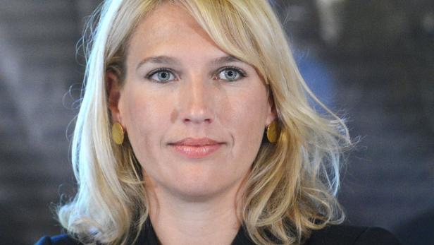 Nahaufnahme einer Frau mit blonden Haaren und goldenen Ohrringen.