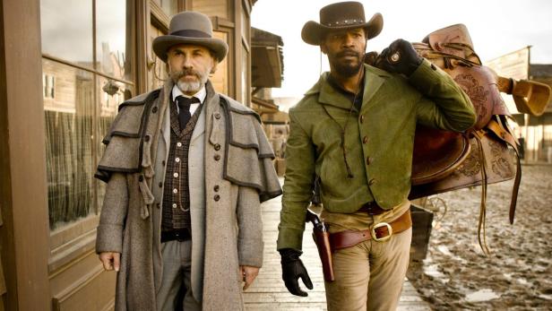 Christoph Waltz und Jamie Foxx in Kostümen vor einer Westernstadt-Kulisse.