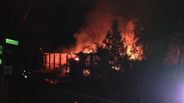 Ein Gebäude steht in Flammen, Rauch steigt auf.