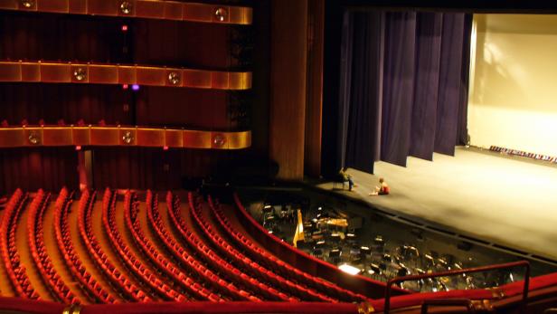 Blick von einem Balkon auf die Bühne eines Theaters mit zwei Personen.