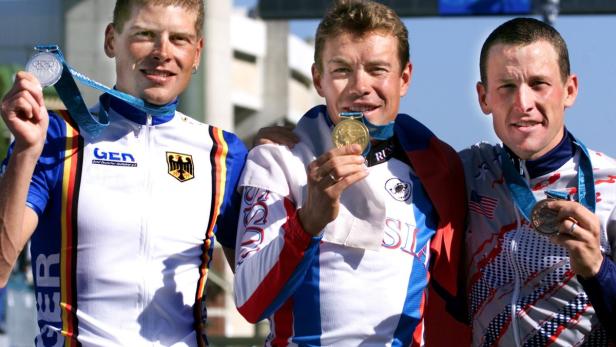 Jan Ullrich, Wladimir Putin und Lance Armstrong bei den Olympischen Spielen mit ihren Medaillen.