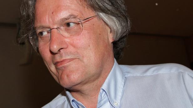 Ein Mann mit Brille und hellblauem Hemd blickt nach links.