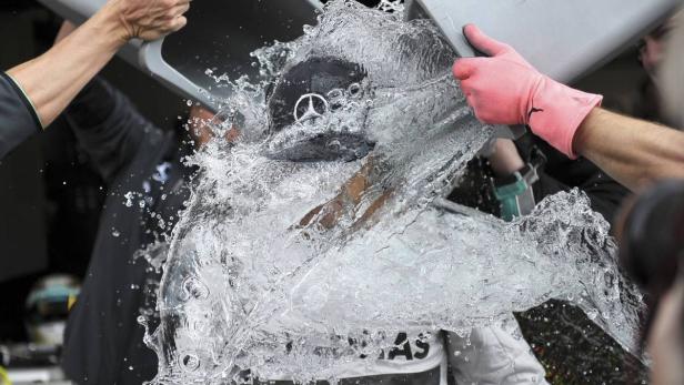 Das Formel-1-Team von McLaren Mercedes schütten Eiswasser über Fahrer Lewis Hamilton