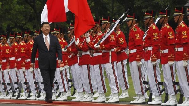Xi Jinping schreitet an einer Ehrenformation in roter Paradeuniform vorbei.