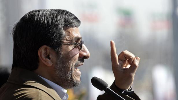 Mahmoud Ahmadinejad gestikuliert während einer Rede vor einem Mikrofon.