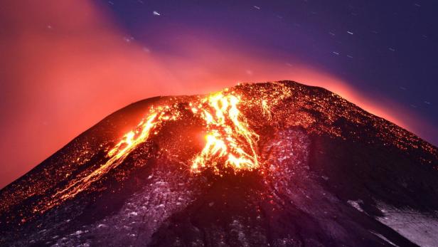 Ein Vulkan bricht aus und Lava fließt den Hang hinunter, während der Himmel sich in Rottönen färbt.
