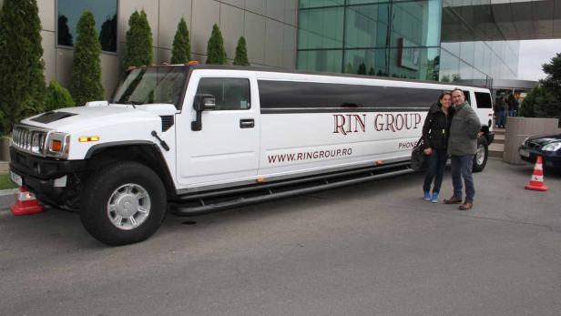 Ein Paar posiert vor einer weißen Hummer-Limousine der „RIN Group“.