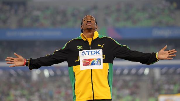 Ein jamaikanischer Athlet steht mit offenen Armen vor einer Zuschauermenge.