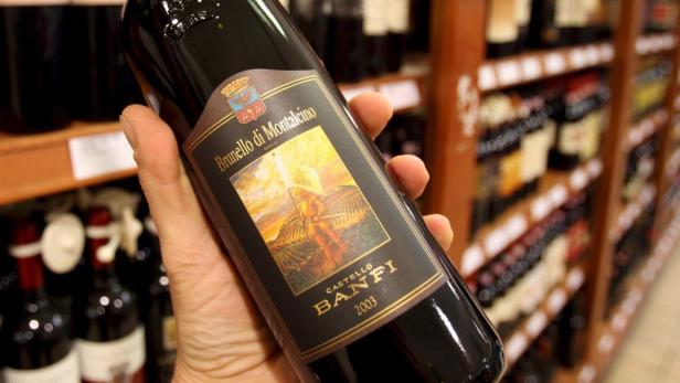 Eine Hand hält eine Flasche Brunello di Montalcino Castello Banfi 2003.