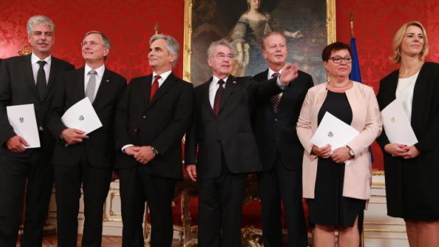 Eine Gruppe von Personen steht in einem formellen Rahmen und hält Dokumente.