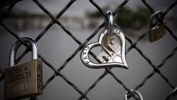 epa02271212 Padlocks placed by lovers adorn the railings of the Pont des Arts bridge on the Seine river in Paris, France, 02 August 2010. Over the last two years, tourists have been flocking to the site, locking personalized love-padlocks, or &#039;cadenas d&#039;amour&#039; on the bridge&#039;s railings and throwing the keys into the Seine river. The Paris municipality has since threatened to remove the estimated 2,000 locks from the bridge in a bid to preserve its heritage. EPA/IAN LANGSDON