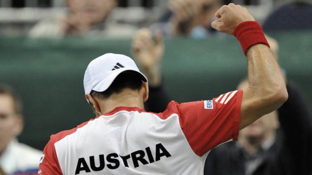 Ein Tennisspieler mit der Aufschrift „Austria“ auf dem Rücken jubelt mit erhobener Faust.