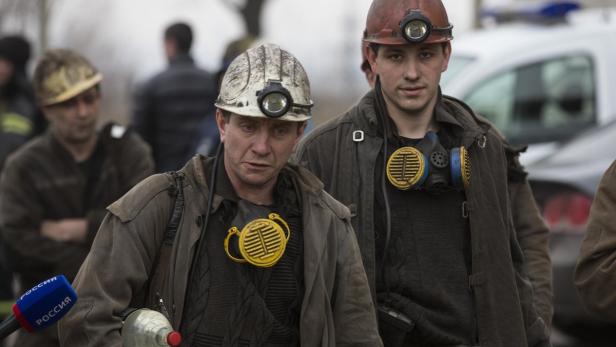 Zwei Minenarbeiter tragen Helme und Atemschutzmasken.