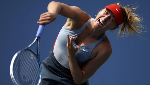 Maria Sharapova of Russia serves to Caroline Wozni