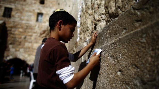Ein Junge mit Kippa betet an der Klagemauer in Jerusalem.