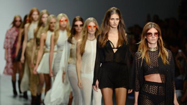 Eine Reihe von Models präsentieren Mode auf einem Laufsteg.