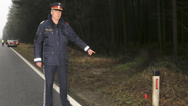 Polizist Ratzenböck an der Stelle, an der Michael K. starb. Neben der Fahrbahn brennt eine Kerze