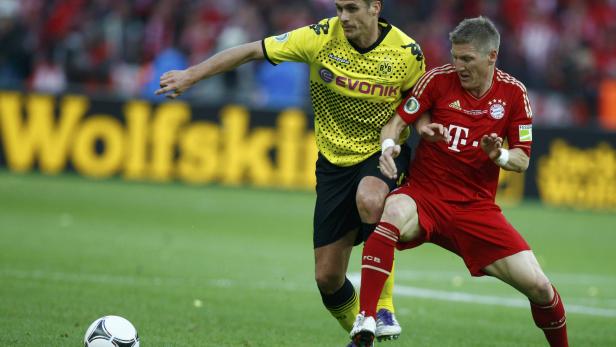 Bayern Munich&#039;s Bastian Schweinsteiger (R) challenges Borussia Dortmund&#039;s Sebastian Kehl during the German DFB Cup (DFB Pokal) final soccer match at the Olympic stadium in Berlin, May 12, 2012. REUTERS/Thomas Bohlen (GERMANY - Tags: SPORT SOCCER) DFB RULES PROHIBIT USE IN MMS SERVICES VIA HANDHELD DEVICES UNTIL TWO HOURS AFTER A MATCH AND ANY USAGE ON INTERNET OR ONLINE MEDIA SIMULATING VIDEO FOOTAGE DURING THE MATCH